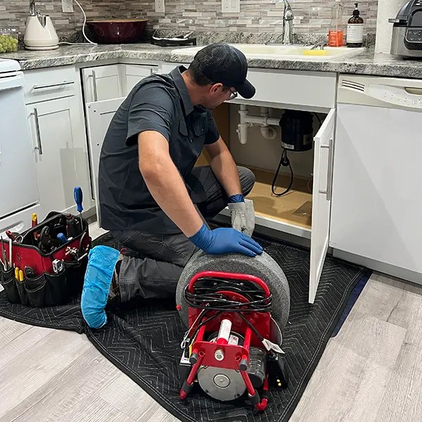 Pipedex plumber performing drain cleaning